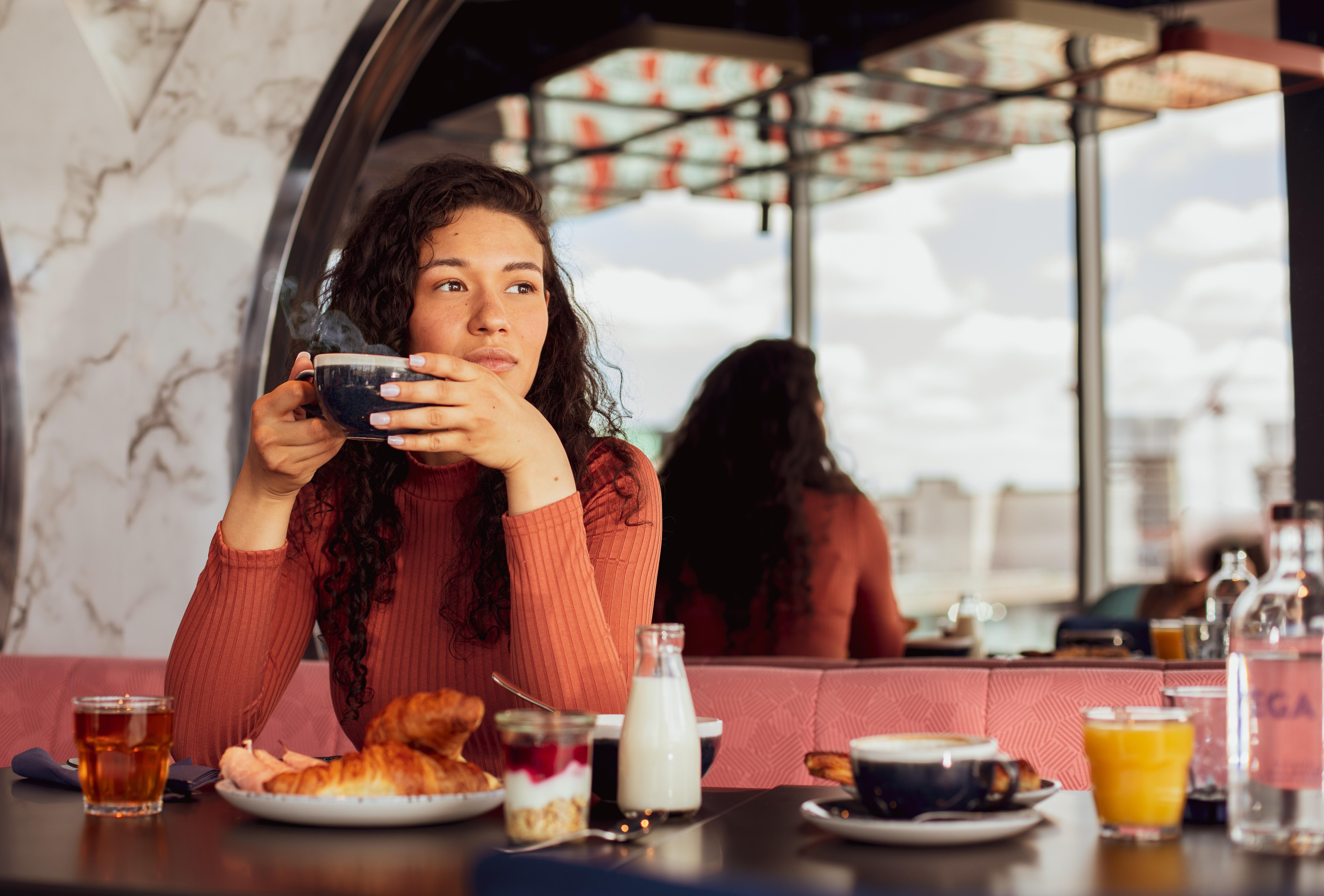 Yotel Glasgow Exterior photo A woman having breakfast at a cafe.