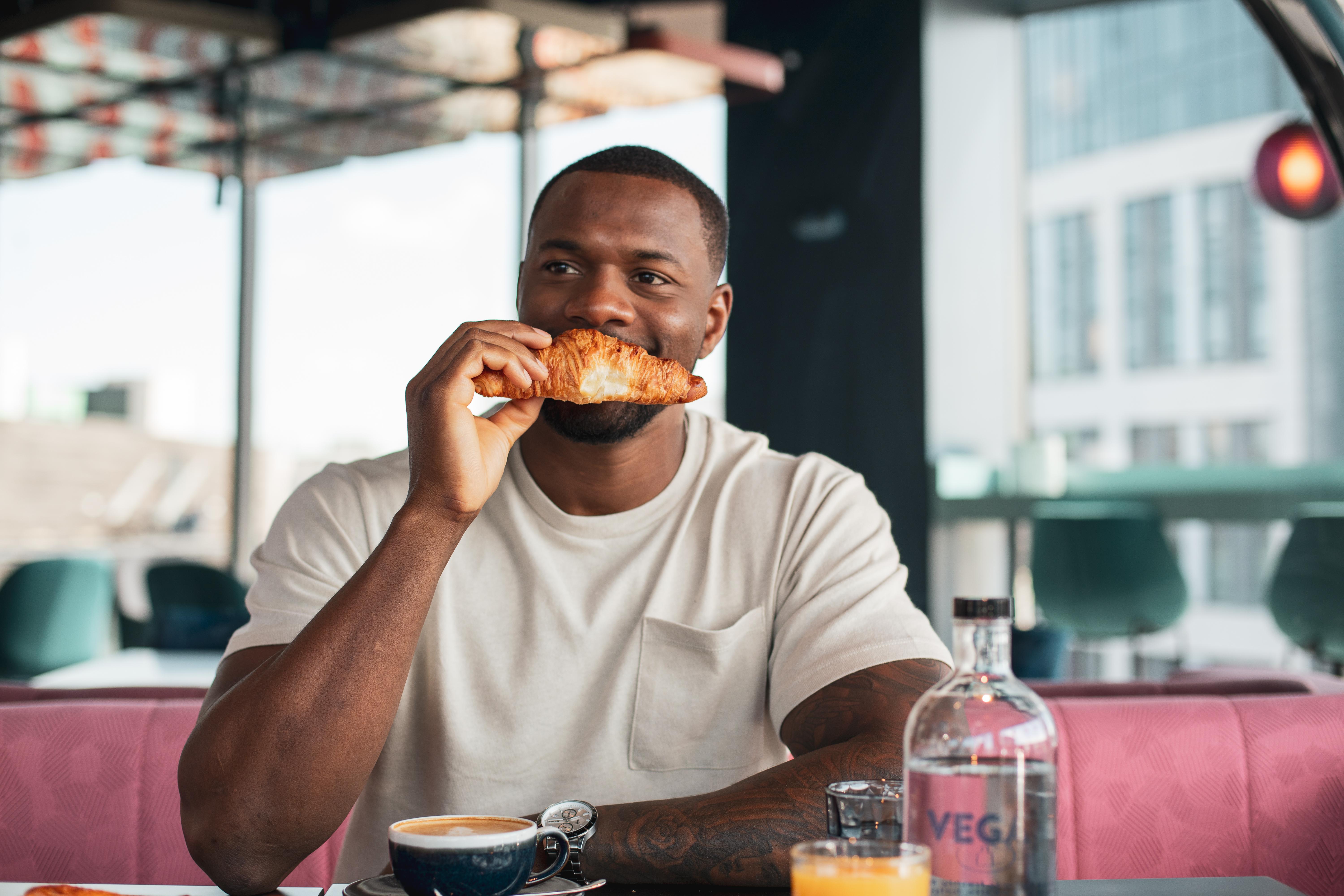 Yotel Glasgow Exterior photo Photo of a man eating a croissant